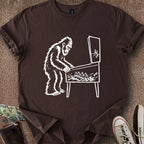 Printify T-Shirt Dark Chocolate / S 0182_bigfoot playing pinball T-Shirt